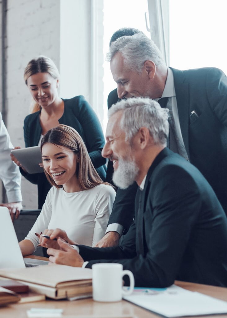 a group of people looking at a laptop