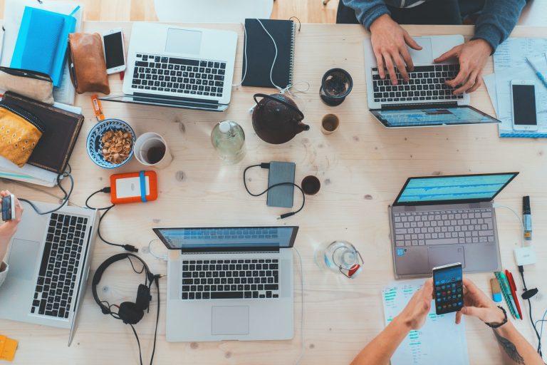 a table with many laptops and electronics on it