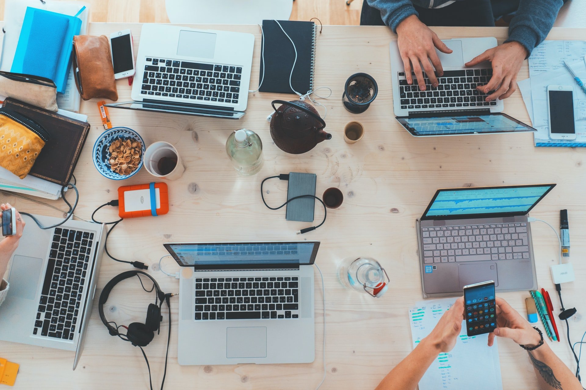 a table with many laptops and electronics on it