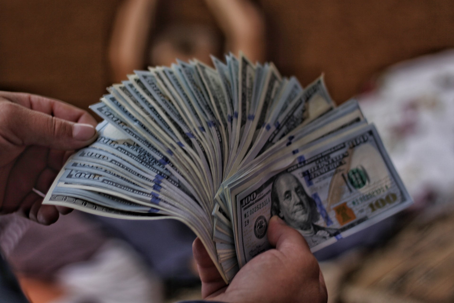 a person holding a fanned out dollar bills