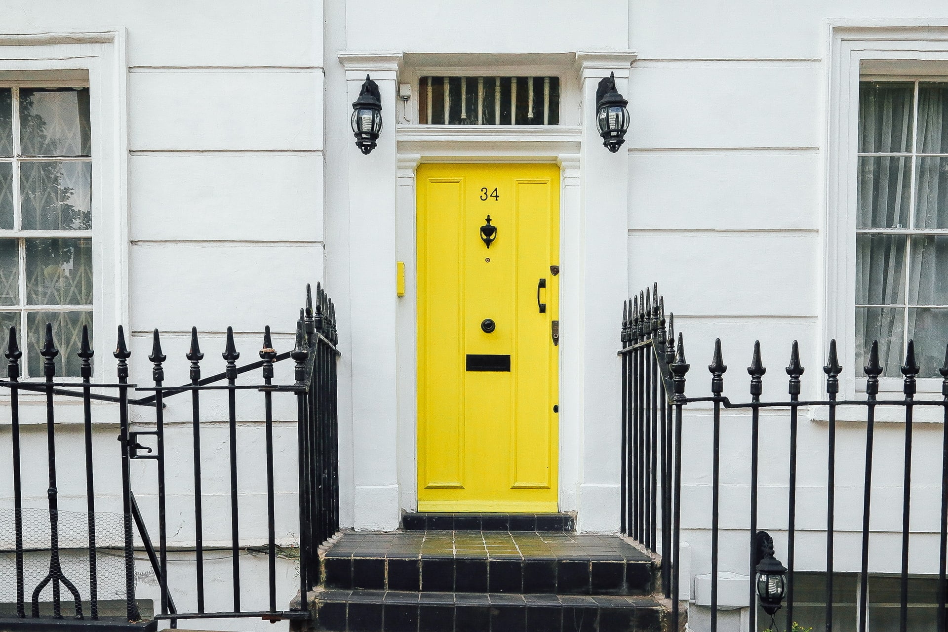 a yellow door on a white house