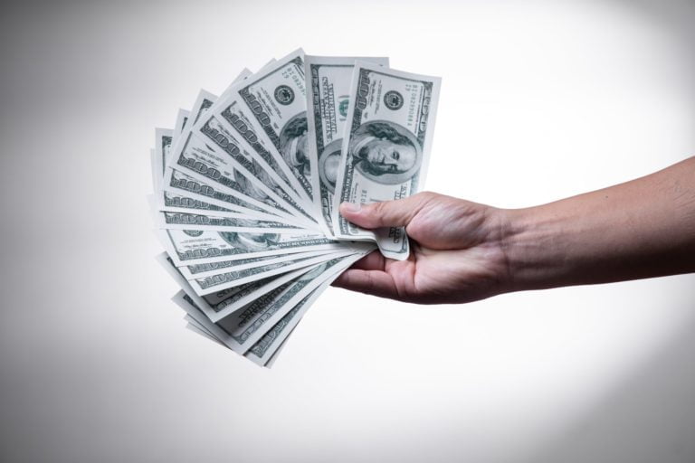 a person holding a stack of paper money