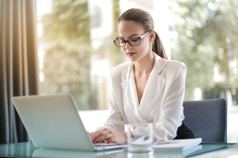 a woman sitting at a table with a laptop