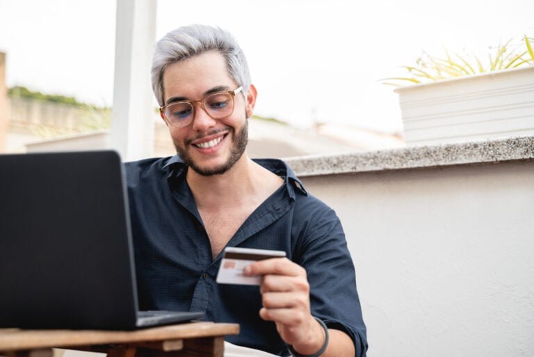 Man holding a credit cart using computer