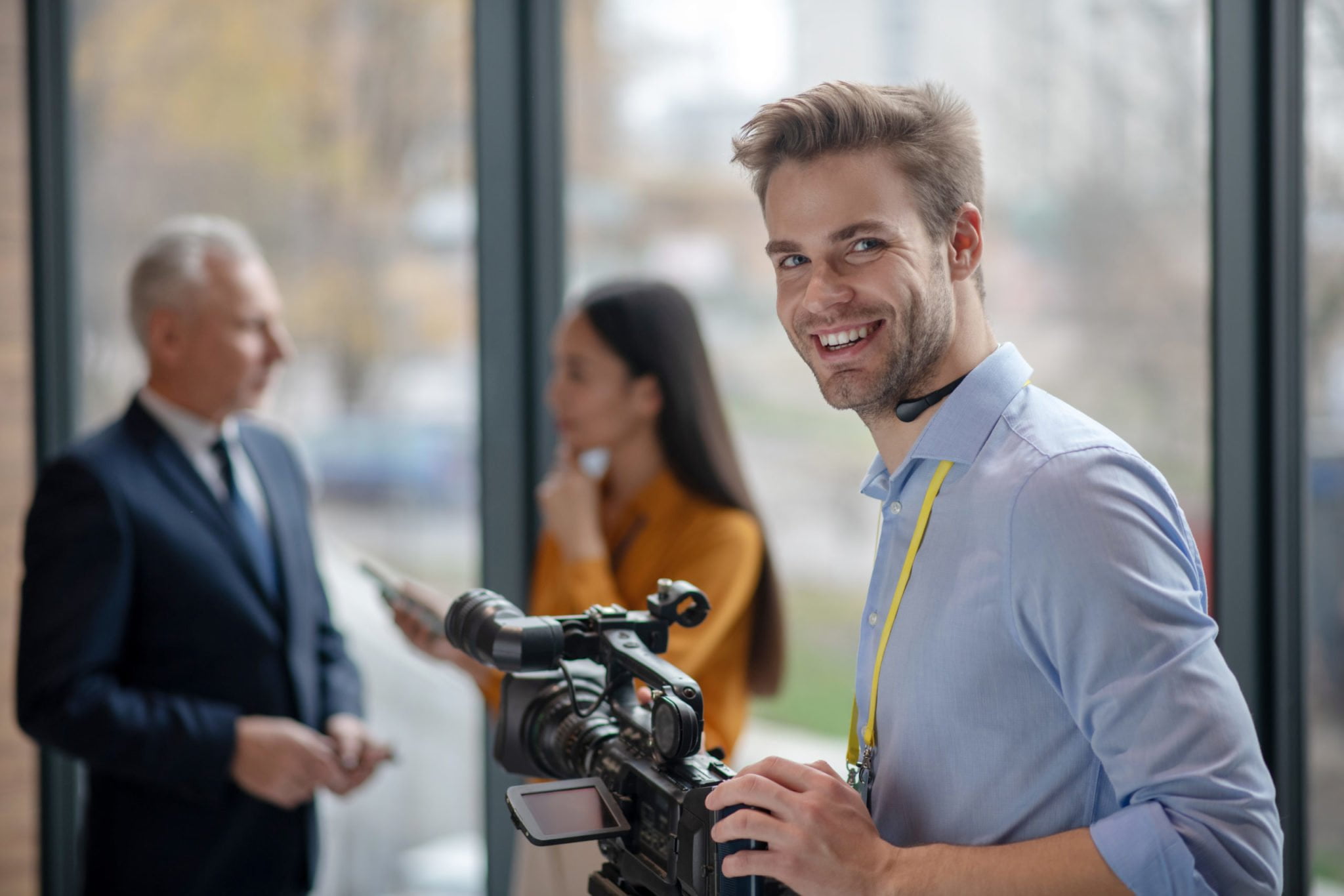 Male young operator with video camera looking satisfied